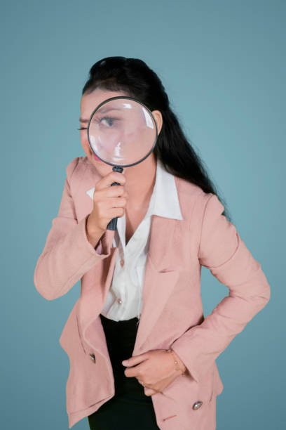 istock Businesswoman looking through a magnifying glass 1070367148