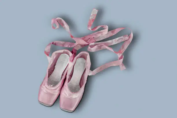 Top view of colored pink ballet shoes with gray background