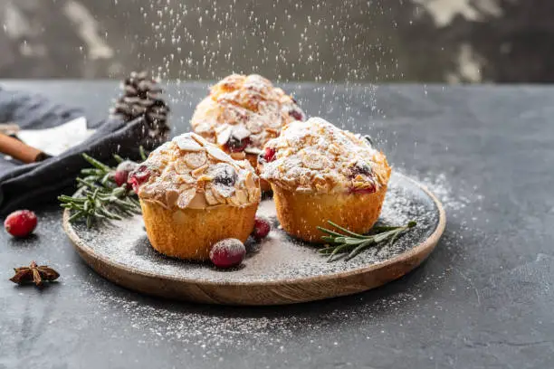 Photo of Muffins, cakes with cranberry, rosemary and almond nuts. Christmas decoration. Copy space.