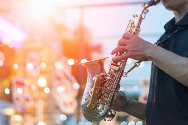 International jazz day and World Jazz festival. Saxophone, music instrument played by saxophonist player musician in fest. International jazz day and World Jazz festival. Saxophone, music instrument played by saxophonist player musician in fest. classical orchestral music stock pictures, royalty-free photos & images