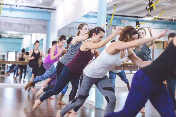 istock Instructor leads a multiethnic group of women through a barre workout 1070371068