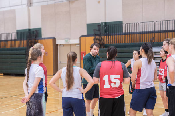 istock Coach pulls his college women's basketball team together for a huddle 1070371304