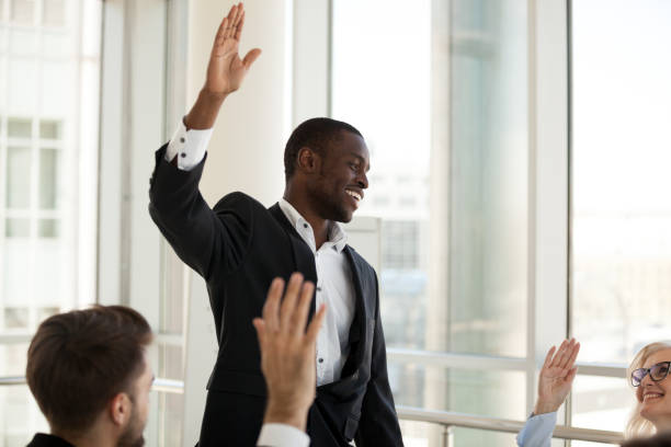 istock Black male coach hold teambuilding activity with workers raising hands 1070375280