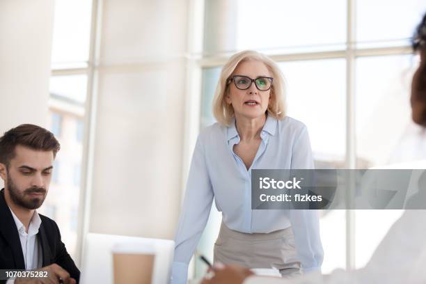 Serious Mature Businesswoman Talk Having Discussion During Briefing Stock Photo - Download Image Now