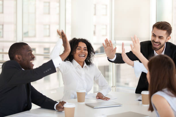 istock Excited diverse employees give high five at team meeting 1070375338