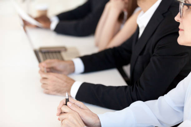 istock Close up of diverse employees sitting in row at table 1070375434