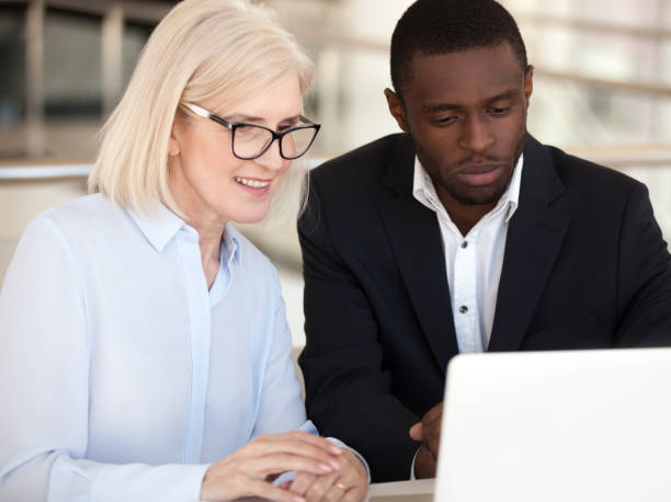 istock Diverse employees coworking using computer at office meeting 1070375440