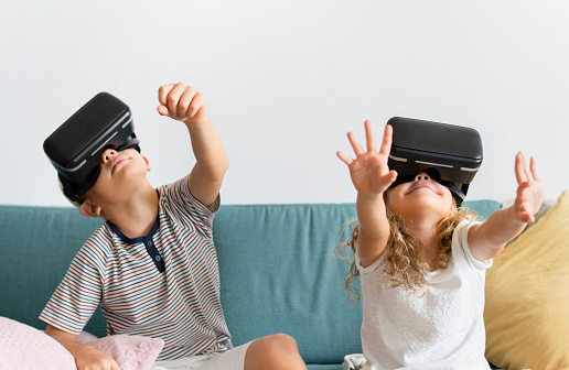 Little kids watching movies on their VR goggles