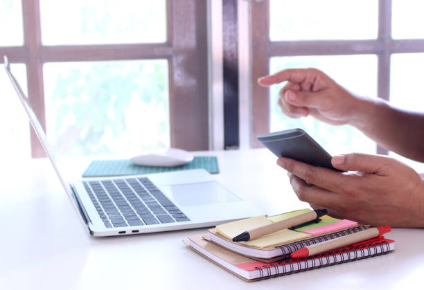 istock side view,business man holding smartphone and point.office table desk. workspace with notebook and mouse on copy space 1070376880
