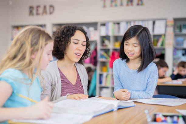istock Teacher helping 4th graders in her classroom 1070377384