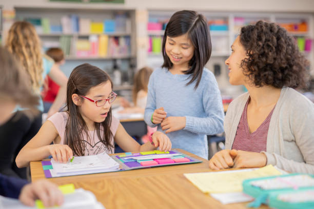 Teacher helping 4th graders in her classroom