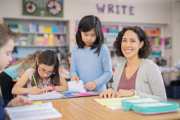 istock Teacher helping 4th graders in her classroom 1070377410