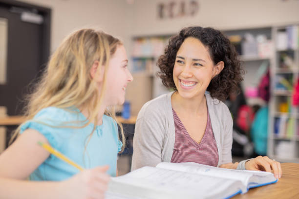 istock Teacher helping a 4th grader in her classroom 1070378898