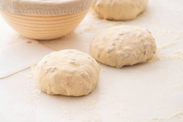 Baking bread. Dough in proofing basket on wooden table with flour. Top view.