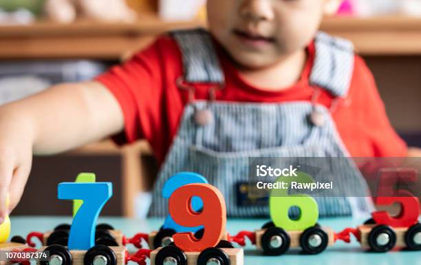 Little Boy Playing Mathematics Wooden Toy At Nursery Stock Photo - Download Image Now