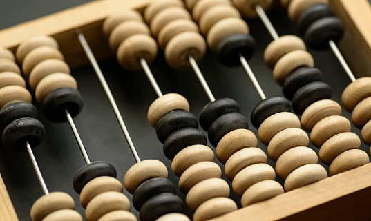 Old wooden abacus on dark background.