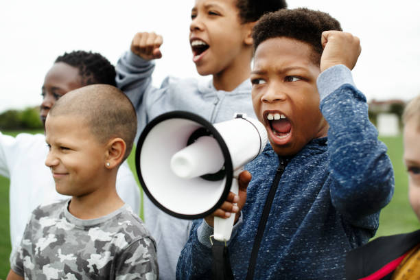 Young boy shouting on a megaphone in a protest
