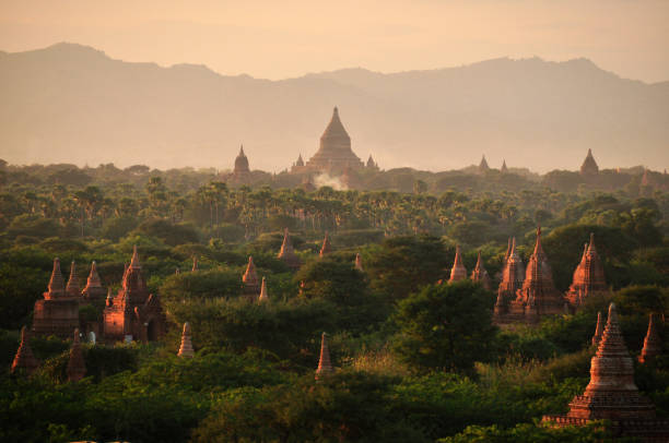 green land with spears of temple, picturesque landscape of green spacious terrain with spires of oriental pagodas and paya, myanmar, bagan. mingalazedi sulamani shwezigon ananda htilominlo. - paya imagens e fotografias de stock