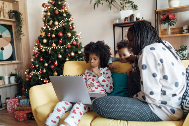 istock Mother and daughters watching cartoons on laptop 1070403126