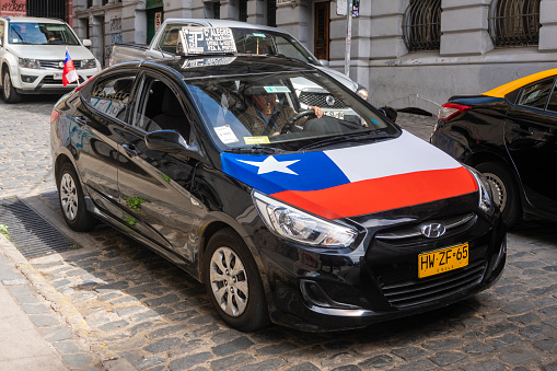Valparaiso, Chile - Sep 19, 2018: Taxi with flag of Chile travelling in the town of Valparaiso. It is a city in Chile known for its street arts.