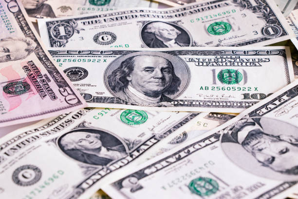 istock US dollar bills as background, scattered banknotes, american money 1070416782