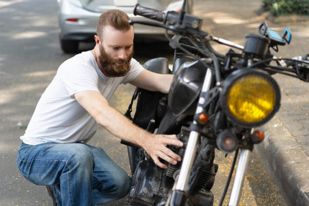 Serious biker diagnosing broken motorbike