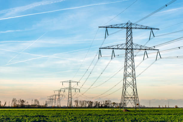 torres de alta tensión con gruesas colgando de cables de potencia en un paisaje rural en los países bajos - cable de energía eléctrica fotografías e imágenes de stock