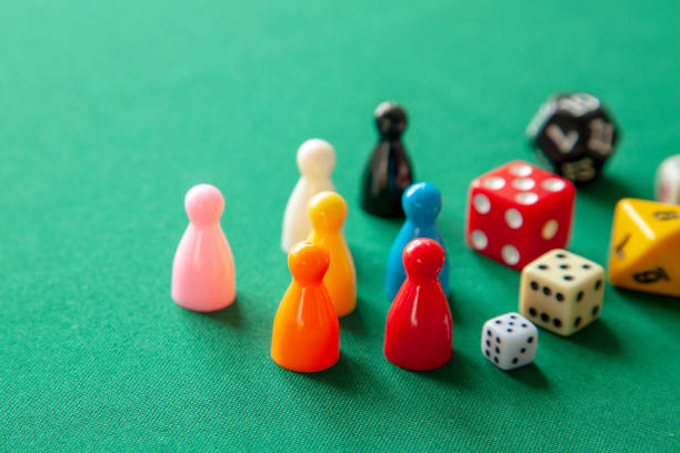 istock Colored game figures chips for board games. Collection of dice cubes on green table 1070444812