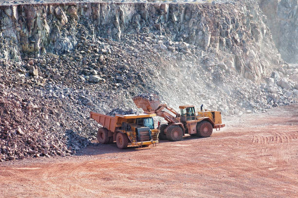 istock dumper truck gets load by excavator in a quarry mine 1070451376