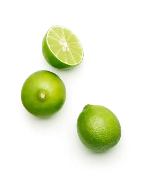 Fresh lime over white background, top view