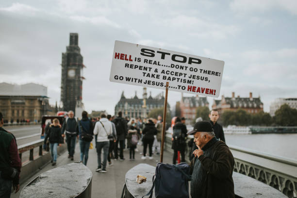 ekscentryczny mężczyzna pokazujący wiadomość na tablicy związanej z jezusem w londynie w wielkiej brytanii. - heaven hell road sign sign zdjęcia i obrazy z banku zdjęć