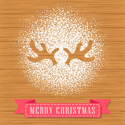 Decorate a reindeer antler shape with powdered sugar on hardwood background for Christmas