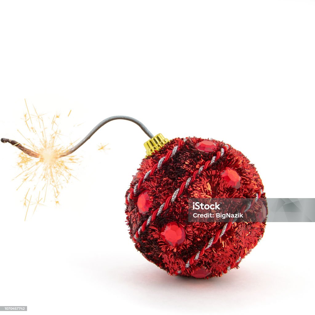 Christmas tree decoration. Red bomb ready to go off with golden sparkles on white background. New Year concept Christmas tree decoration. Red bomb ready to go off with golden sparkles on white background. New Year concept. Explosive Fuse Stock Photo