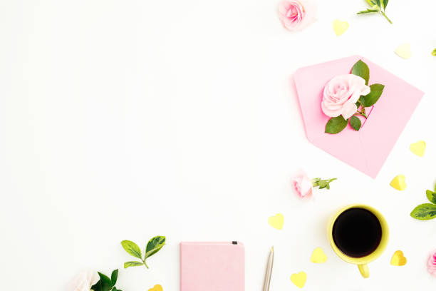 istock Valentines day composition with roses flowers, paper envelope and coffee mug on white background. Flat lay, top view. 1070488552