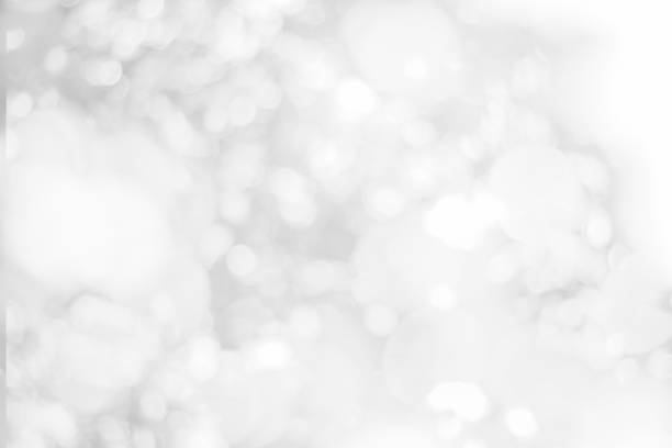 istock Abstract glamorous white and silver bokeh lights glitter sparkle. Defocused background have luxury golden color party invite for birthday, anniversary, holliday, new year xmas or snow christmas blur. 1070497274