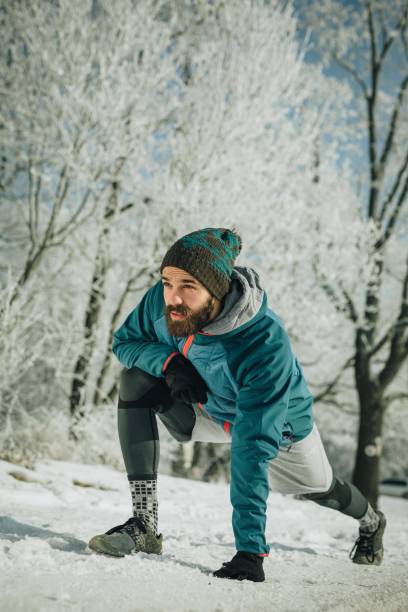 istock Athletic man stretching his leg during winter day in nature. 1070497504