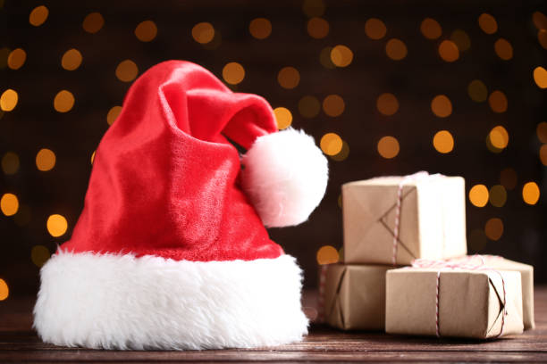istock Santa claus hat with gift boxes on bokeh lights background 1070501830