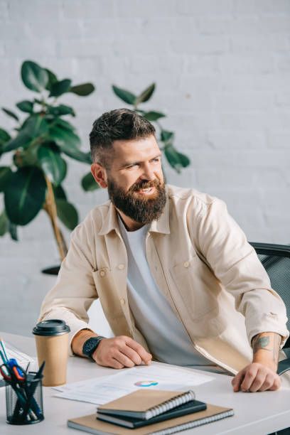 istock Handsome smiling businessman sitting at office desk 1070502112