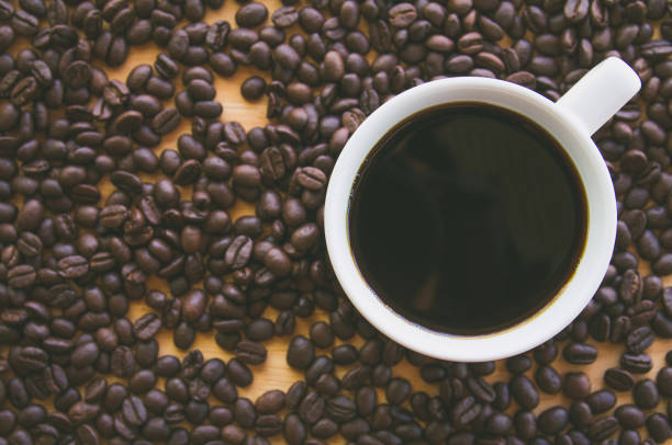 istock Black coffee in a white coffee cup with coffee beans background 1070506730