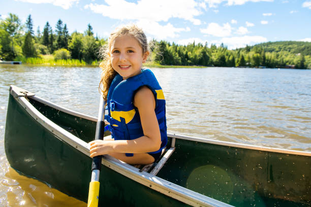 niño feliz disfrutando el paseo en canoa en río hermoso - kayak canoeing canoe lake fotografías e imágenes de stock