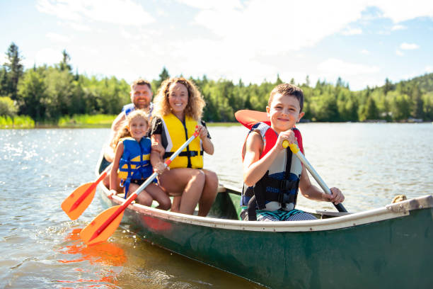familie in einem kanu auf dem see, spaß - rowboat river lake nautical vessel stock-fotos und bilder