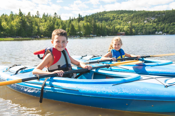 summer vacation portrait of cute boy and girl kayaking the on river - family kayaking kayak canoeing imagens e fotografias de stock