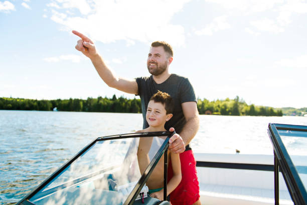 istock Man driving boat on holiday with his son kid 1070509664
