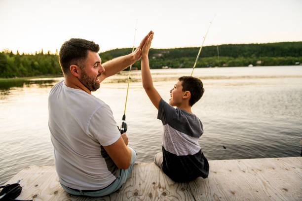 cool papa et fils de pêche sur le lac - fishing father son family photos et images de collection