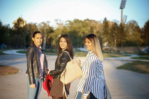 istock Three beautiful young women walking in autumn park 1070511194