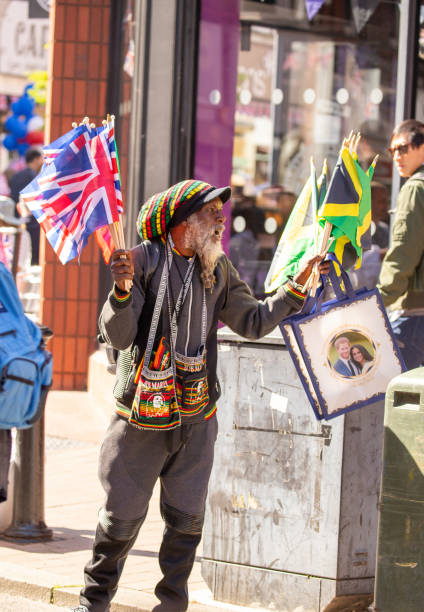 camelô vendendo roupas de casamento real para as multidões de pessoas nas ruas de windsor, levando para o castelo de windsor onde o casamento de meghan markle e príncipe harry - nobility wedding crowd british flag - fotografias e filmes do acervo