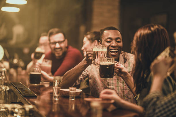 istock Large group of people drinking beer during night out in a bar. 1070513408