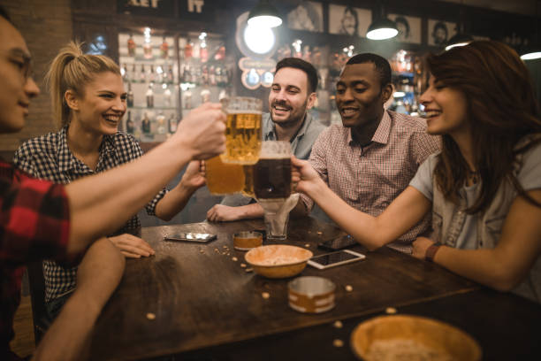 istock Happy friends having fun while toasting with beer during their night out in a bar. 1070513716