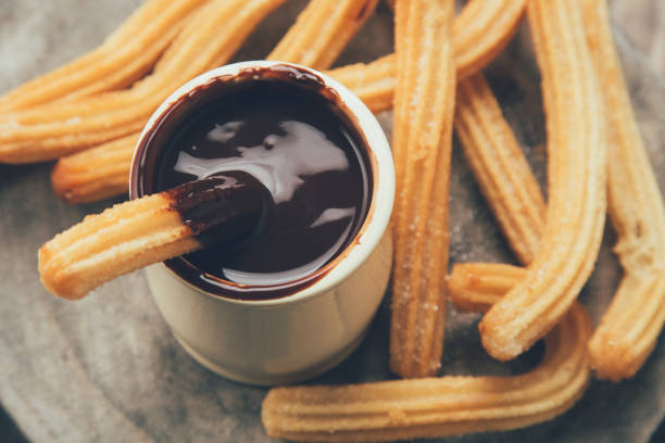 istock Churros with hot chocolate sauce in a rustic mood 1070515086