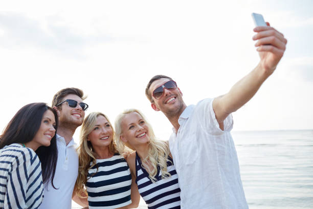 istock happy friends on beach and taking selfie 1070526496
